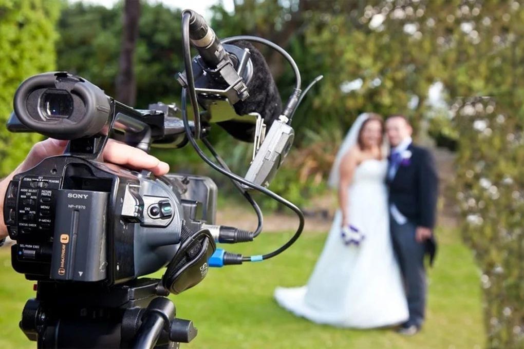 Wedding videographer filming a couple